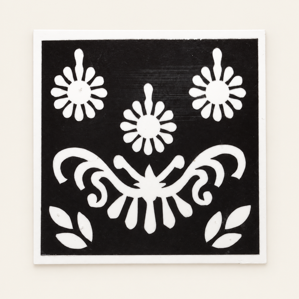 Floral Charm actual stencil design on white backing, displayed against a cleaned ivory background.